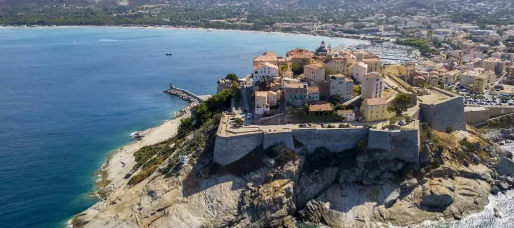 Vue aérienne de Calvi et sa citadelle au bord de la mer, destination emblématique pour la plongée sous marine en Corse