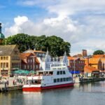 Vue du port de Flensburg avec bateaux, bâtiments colorés et église en arrière-plan, un lieu paisible pour la plongée en mer Baltique