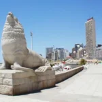 Statue du lion de mer à Mar del Plata avec la plage et la ville en arrière-plan