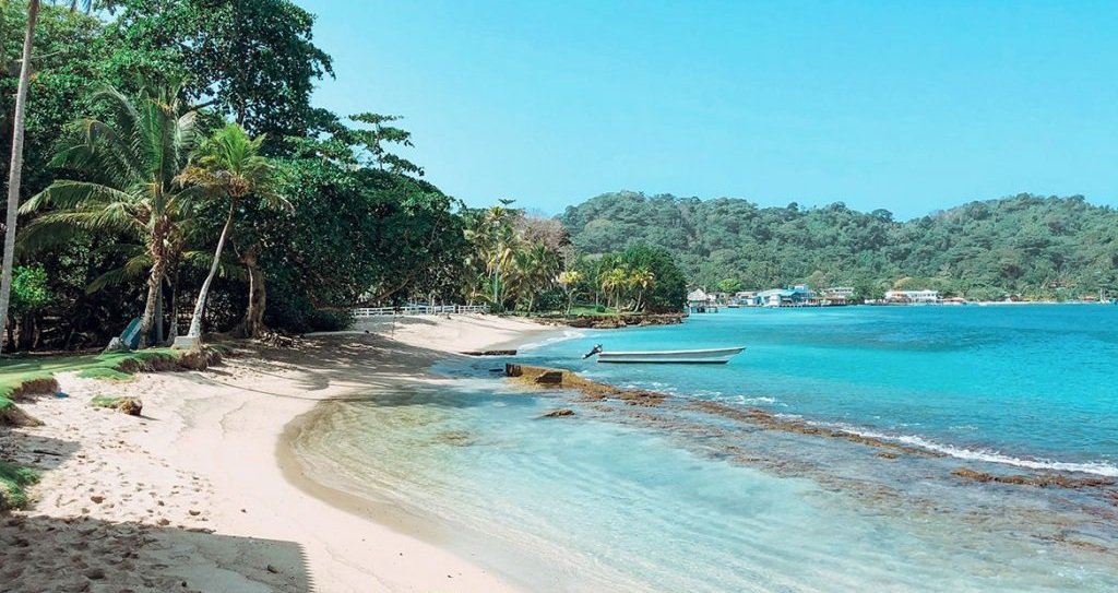 Plage de Capurganá face au village caribéen, mer turquoise et palmiers