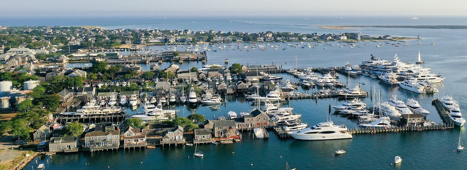 Vue aérienne du port de Nantucket avec ses jetées, ses bateaux et les maisons en bois caractéristiques de l’île