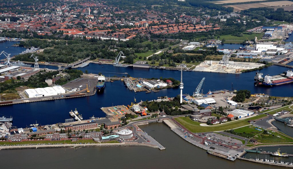 Vue aérienne du port de Wilhelmshaven avec ses quais, ses navires et les zones industrielles autour de la baie de Jade.
