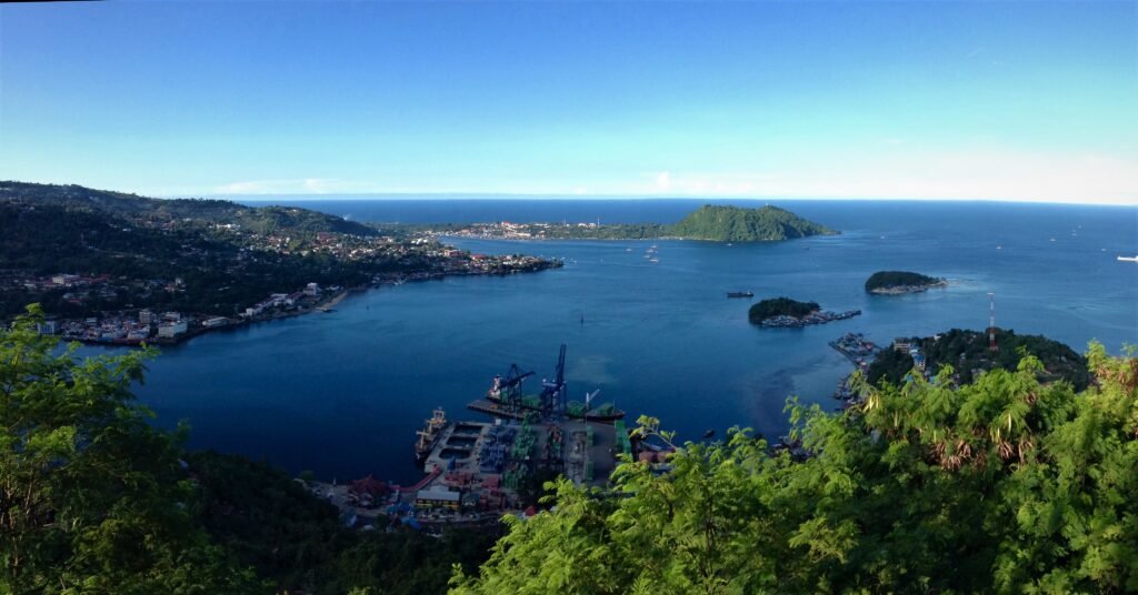 Vue panoramique de la baie de Jayapura avec le port, les collines verdoyantes et les îlots côtiers en Papouasie indonésienne