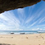 Plage isolée près de Karachi vue depuis une cavité rocheuse avec l’océan et un ciel bleu