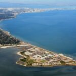 Vue aérienne de Corpus Christi montrant la baie, la côte texane et le Golfe du Mexique avec les zones lagunaires et urbaines.