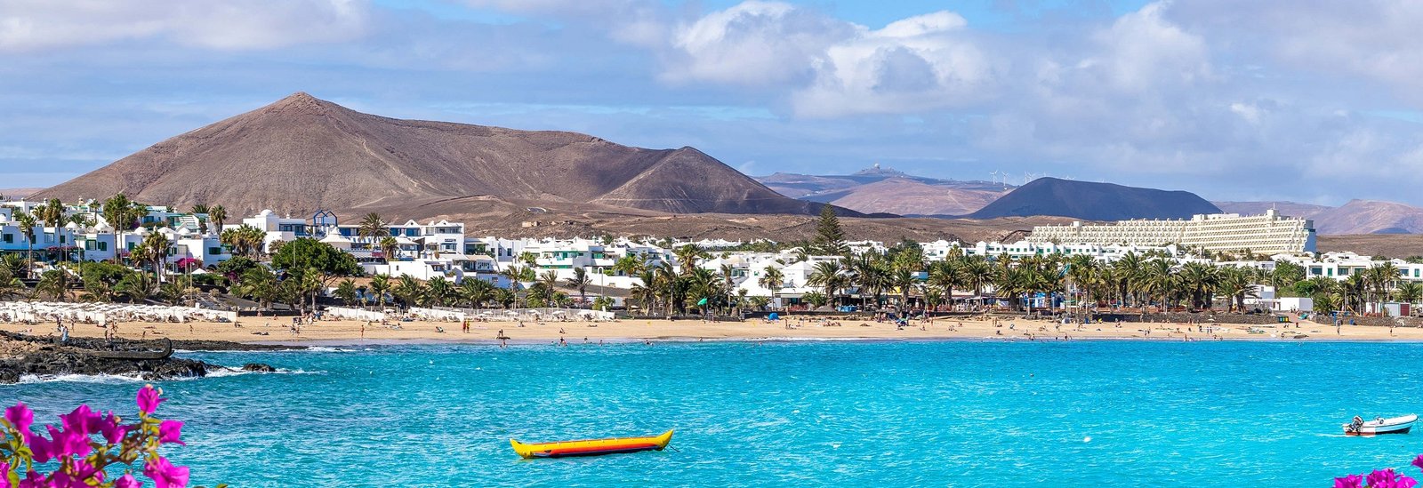 Vue de Costa Teguise à Lanzarote avec plage, eau turquoise et reliefs volcaniques