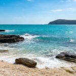 Plage rocheuse de l’île de Weizhou avec eau turquoise et falaises volcaniques en mer de Chine méridionale
