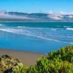 Plage sauvage de Crescent City en Californie avec vagues, sable et côte brumeuse idéale pour la plongée