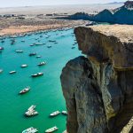 Vue du littoral de Chabahar sur le golfe d’Oman en Iran, entre falaises rocheuses et bateaux de pêche près des sites de plongée